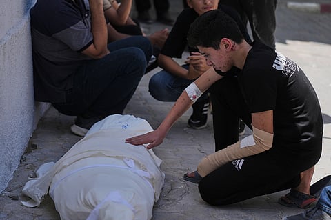 Omar Klaub, injured in an Israeli strike, mourns beside the body of his mother, Rana, who was killed in the same attack, during her funeral at Shifa Hospital in Gaza City, Thursday, June 4, 2026. 