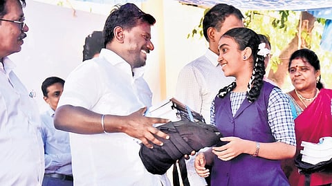 Minister for School Education Rajmohan distributing textbooks to a student at the government higher secondary school in Arumbakkam, Chennai.