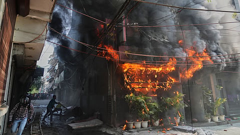 Local people attempt to douse a fire at a hotel in New Delhi, India, Wednesday, June 3, 2026.