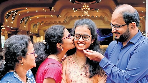 Tanisha Karthik, who secured first rank in  CET Engineering 2026, celebrates with her family in Bengaluru