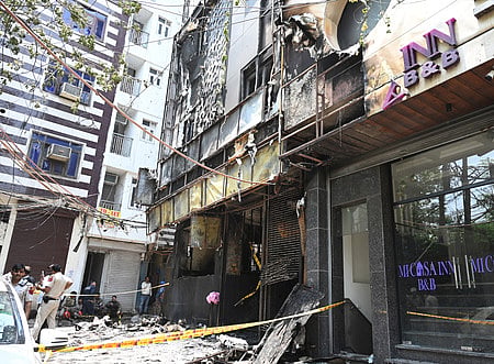 Police and Fire Brigade personnel at the site where a fire broke out in a restaurant at Malviya Nagar, in New Delhi on Wednesday