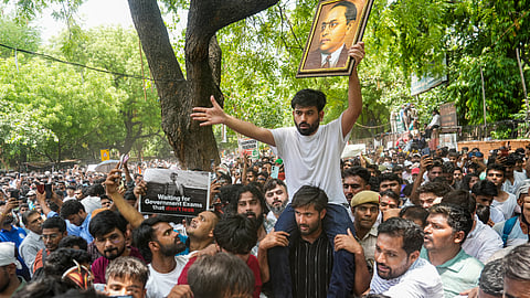 A supporter carries the Cockroach Janta Party (CJP) founder Abhijeet Dipke, in white, over his shoulder during a protest demanding the resignation of Union Education Minister Dharmendra Pradhan over alleged examination-related lapses, at the Jantar Mantar, in New Delhi, Saturday, June 6, 2026