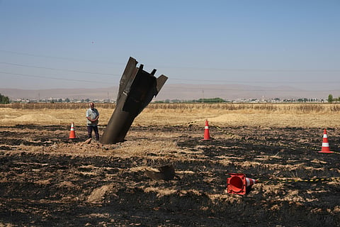 A Syrian farmer stands next to an Iranian missile that fell into an agricultural land in the area of Najha, in the countryside of the Syrian capital after being intercepted by Israeli air defense systems on June 8, 2026.
