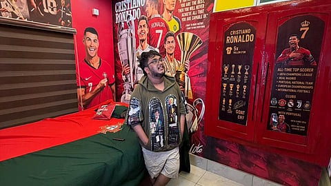 Muhammad Roshan in his bedroom decorated with pictures of Cristiano Ronaldo and the jersey design of the Portugal team.