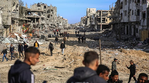 Palestinians walk amongst the destruction caused by the Israeli air and ground offensive, Sunday, Jan. 19, 2025, in Rafah, as a ceasefire deal between Israel and Hamas went into effect.