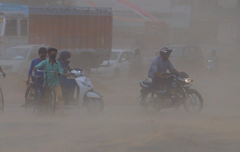 Commuters pass by amid dust storm, in Gurugram, Haryana, Tuesday, June 9, 2026.