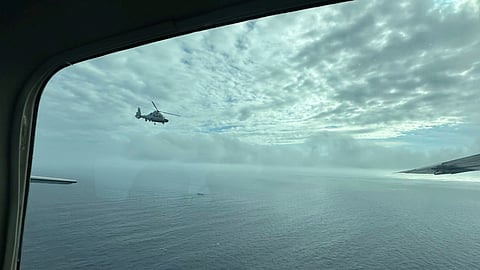 A Chinese military helicopter flies close to a Philippine Bureau of Fisheries and Aquatic (BFAR) aircraft above Scarborough shoal on Feb. 18, 2025. 