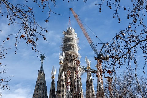 A crane lifts the final piece of the 17 meters high and 13.5 meters wide cross that completes the Sagrada Familia's Tower of Jesus Christ in Barcelona 