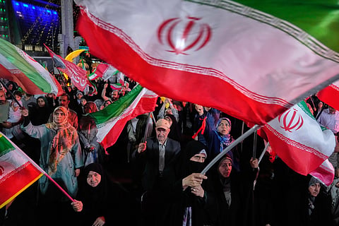 Demonstrators wave Iranian flags in a pro-government gathering in Tehran, Iran, Sunday, June 7, 2026.