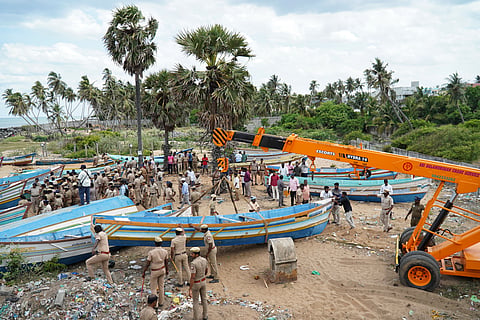Police and revenue officials remove boats from the disputed burial ground site at Nadukuppam near Kottakuppam in Villupuram district on Tuesday.