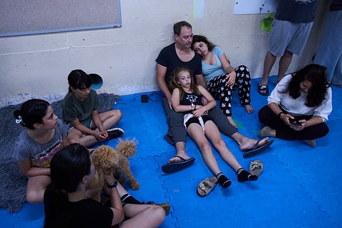 People take shelter as air raid sirens warn of incoming Iranian missiles in Ramat Gan, Israel, Monday, June 8, 2026. 