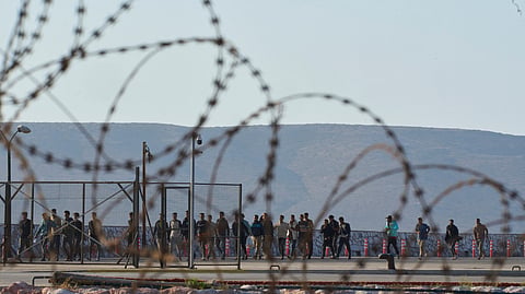 Migrants rescued south of Crete walk after their arrival at the the port of Lavrio, Greece, on July 10, 2025.