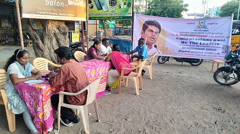 Volunteers at a street-corner membership helpdesk in Edamalaipatti Pudur 