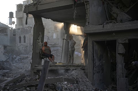 Palestinians clear the rubble of a building that was destroyed in an Israeli airstrike, at al-Maghazi refugee camp, central Gaza Strip, Friday, June 12, 2026
