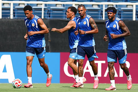 Football players practicing on a sun-drenched training pitch ahead of world cup matchday