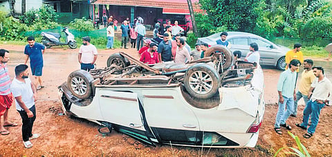 The toppled car in which four members of the SIT, probing the Dharmasthala case, near Charmadi Ghat on Tuesday 