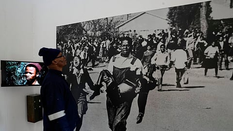A man looks at June 16 iconic image taken by the late Sam Nzima displayed at The Hector Pieterson Memorial and Museum, in Soweto, South Africa.
