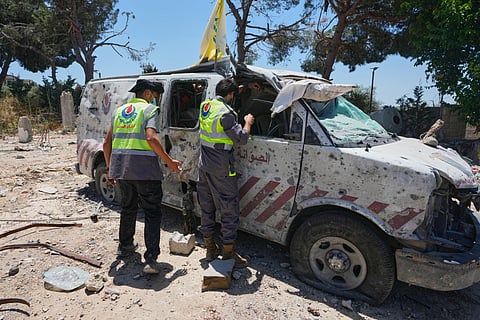 Rescue workers inspect a damaged ambulance belonging to Hezbollah's health unit that was hit in a previous Israeli airstrike in the southern village of Souaneh, Lebanon, Tuesday, June 16, 2026. 