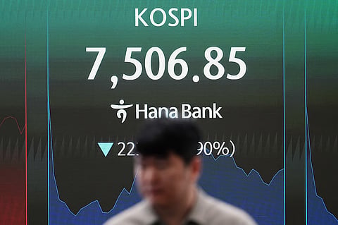 A dealer walks past a screen showing the Korea Composite Stock Price Index (KOSPI) at a dealing room of Hana Bank in Seoul, South Korea, Thursday, June 11, 2026.