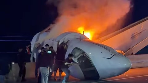 People attempt to pull passengers out of a plane after it crashed on a highway Tuesday, June 16, 2026, in Laredo, Texas.