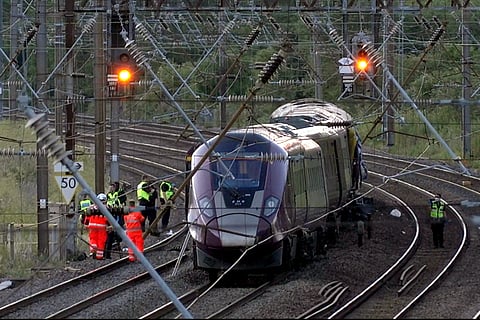 Emergency personnel work on a train on the tracks outside Bedford, England, after a train from Corby to London St. Pancras and another from Nottingham to London St. Pancras, collided on Friday June 19, 2026.