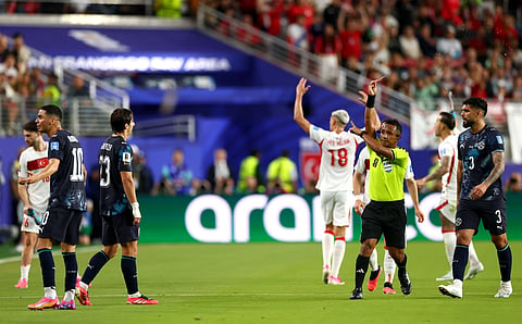 Referee Ivan Barton (2nd from R) issues a red card to Miguel Almiron (Extreme L)