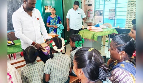 A man seen displaying the portraits to schoolchildren.