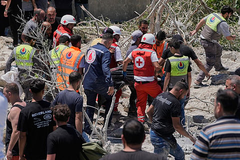 Rescue workers carry a victim that was found under the rubble of a destroyed building hit in an Israeli airstrike in Qannarit village, southern Lebanon, Saturday, June 20, 2026. 