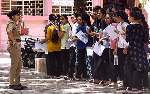Candidates wait in a queue before appearing for the NEET-UG re-examination at an exam centre, in Rajkot, Gujarat, Sunday, June 21, 2026. 