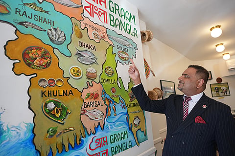Oli Khan, the senior vice president of the Bangladesh Caterers Association UK, shows a map at a Bangladeshi restaurant in London, Thursday, June 18, 2026. 