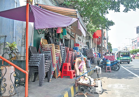 Shopkeepers display merchandise on a footpath along Eluru Road in Vijayawada.