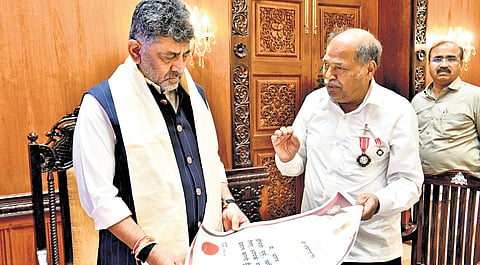 CM DK Shivakumar with Padma Shri awardee Ankegowda in Bengaluru on Monday.