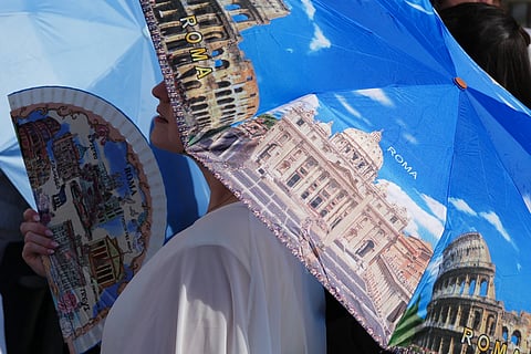 A faithful cools off as they wait for Pope Leo XIV weekly general audience in St Peter's Square at The Vatican, Wednesday, June 24, 2026.