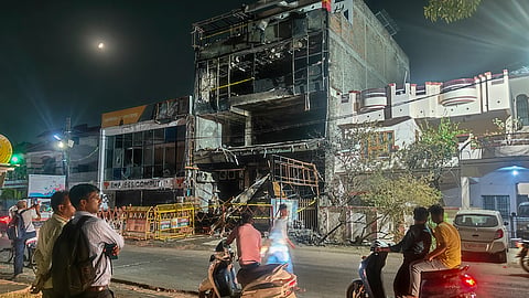 Onlookers stop by the three-storey building, where a fire on Monday killed 15 people, in Lucknow, Uttar Pradesh, late Tuesday, June 23, 2026.