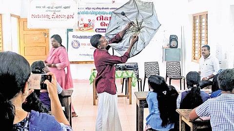 A local mender demonstrates umbrella repair technique to students at VHSS, Keezhvaipur, as part of the ‘repair fest’ initiative promoting reuse and sustainability.