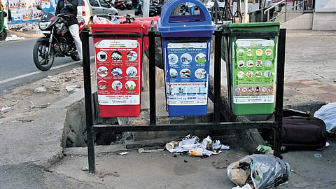 Waste lying scattered outside the newly set up colour-coded bins at a commercial street in Vijayawada.