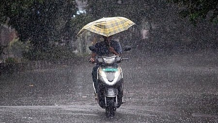 A motorist makes his way through a sudden spell of rain in Bengaluru.