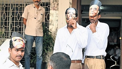 Youth Congress members wear RSS uniform during a protest outside the KPCC office in Bengaluru on Thursday.