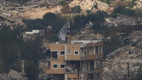 An Israeli flag on a destroyed building in southern Lebanon, as seen from northern Israel, Saturday, June 27, 2026 after Israel and Lebanon sign a framework agreement, described as a first step toward peace following months of conflict between Israel and the Lebanese militant group Hezbollah.
