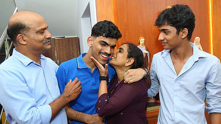 KEAM 2026 state topper Roshan Raju celebrates with his family after securing the first rank in the examination at his residence in Ernakulam.