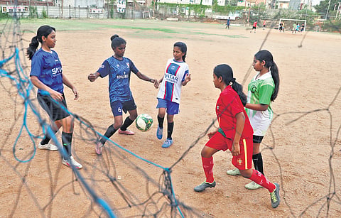 R Keshwardhini, better known as Mary, plays football with a group of girls; boys in football jerseys 