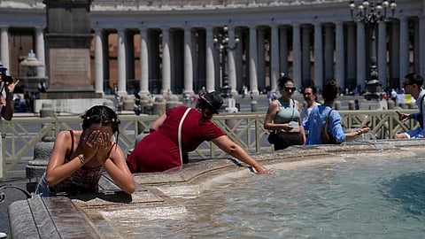 People refresh in a fountain after the Angelus noon prayer celebrated by Pope Leo XIV from the window of his studio overlooking St Peter's Square, at the Vatican, Sunday, June 28, 2026. 