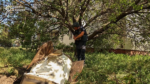 In this photo provided by the Ukrainian Emergency Service, a sapper examines a fragment of the Russian missile in a residential neighbourhood following an air attack in Kyiv, Ukraine, Sunday, June 28, 2026. 