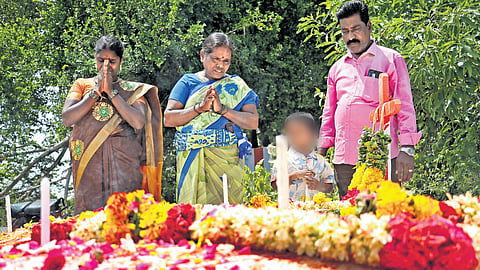 Family members of a victim pay tributes at his grave.