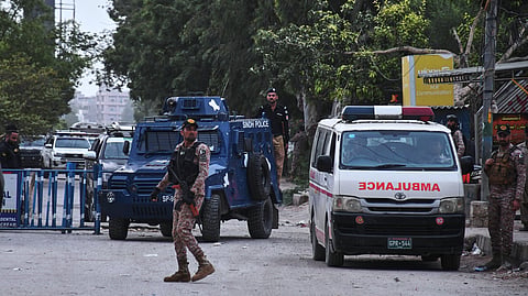 Paramilitary soldiers and police officers stand guard on a road cordoned off near the site of a militant attack at the provincial headquarters of the paramilitary Pakistan Rangers in Karachi, Pakistan, Sunday, June 28, 2026. 