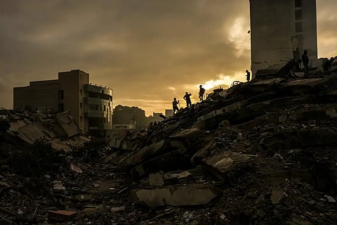 Men searching for survivors stand atop a mountain of rubble three days after twin earthquakes struck, in, La Guaira, Venezuela, Saturday, June 27, 2026.