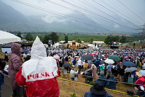 Faithful wait for the start of a consecration ceremony for four new bishops, outside a tent set up outside the society of St Pius X seminary, in Econe, Switzerland, Wednesday, July 1, 2026.
