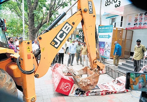 Greater Bengaluru Authority workers remove signboards