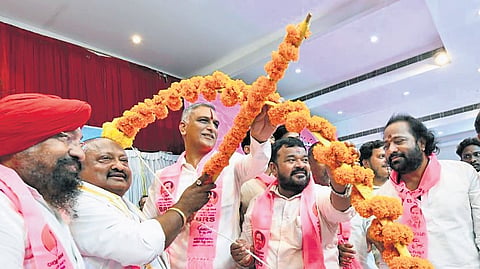 BRS MLA T Harish Rao poses with a bow and arrow presented to him during a meeting in Karimnagar on Wednesday