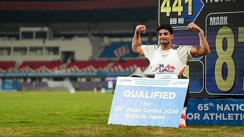 Javelin thrower Rohit Yadav poses with the display board which reads 87.05m at Kalinga Stadium in Bhubaneswar